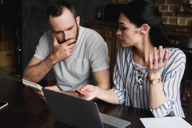 dizüstü bilgisayar ve kredi bölümü sayım hesap makinesi ile genç çift vurguladı