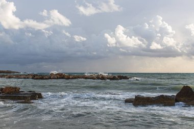 Akdeniz kıyısındaki kayalar bulutlu gökyüzüne karşı 