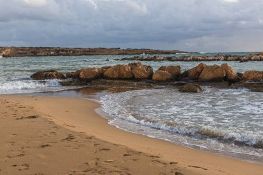 stones near mediterranean sea against sky with clouds  clipart