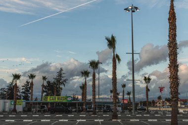 PAPHOS, CYPRUS - 31 Mart 2020: araba yıkama istasyonu ve yeşil palmiye ağaçları 