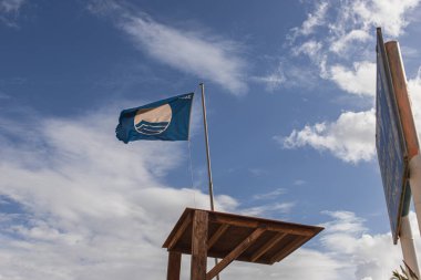 LIMASSOL, CYPRUS - 31 Mart 2020: Uluslararası plaj mükemmeliyeti ödülü olarak mavi bayrağın düşük açılı görünümü 