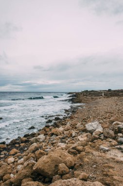 tranquil coastline with stones near mediterranean sea clipart