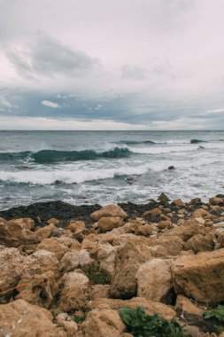 coastline with stones near mediterranean sea against sky clipart