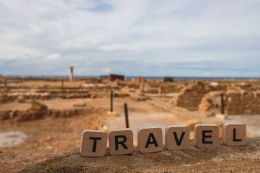 wooden cubes with travel lettering near ruins of ancient House of Theseus   clipart