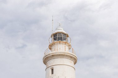 Bulutlu gökyüzüne karşı eski ve beyaz deniz feneri 