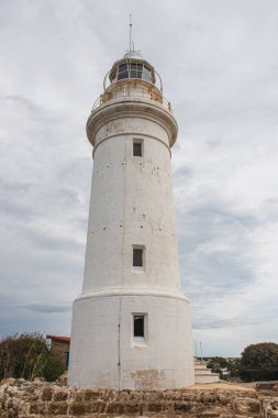 ancient and white lighthouse against sky with clouds  clipart