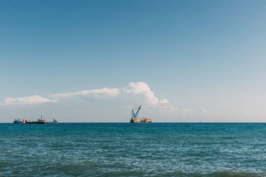 Mavi Akdeniz 'deki gemiler bulutlu mavi gökyüzüne karşı 