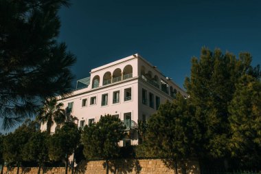Modern evin yanındaki yeşil ağaçlar mavi gökyüzüne karşı