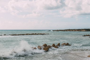 rocks near mediterranean sea against blue sky with clouds  clipart