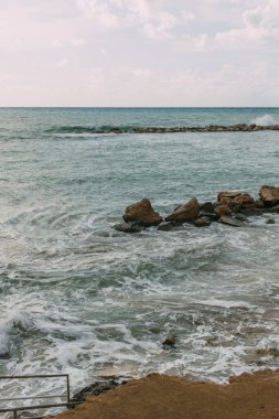 Akdeniz 'deki kayalar bulutlu mavi gökyüzüne karşı 