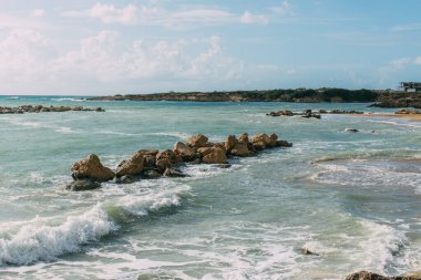 wet rocks in mediterranean sea against blue sky  clipart