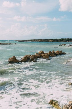 Akdeniz 'de mavi gökyüzüne karşı ıslak taşlar 