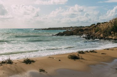 Akdeniz kıyısında mavi gökyüzüne karşı ıslak ve kumlu sahil