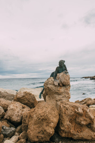 PAPHOS, CYPRUS - MARCH 31, 2020: bronze statue of Sol Alter near mediterranean sea