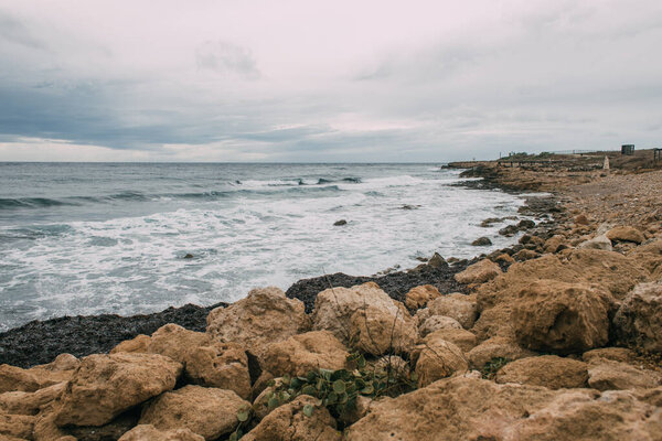 tranquil coastline with stones near blue sea
