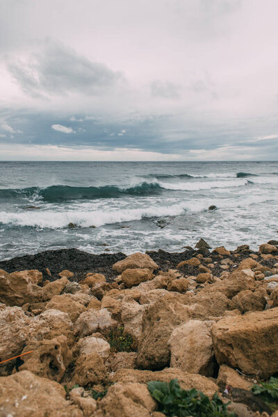 coastline with stones near mediterranean sea against sky