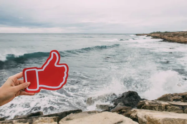 Akdeniz 'e yakın bir yerde baş parmağını kaldıran kadın.