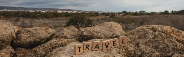 全景照片 木制立方体 旅行用的字母刻在石头上 与天空相对照 — 图库照片