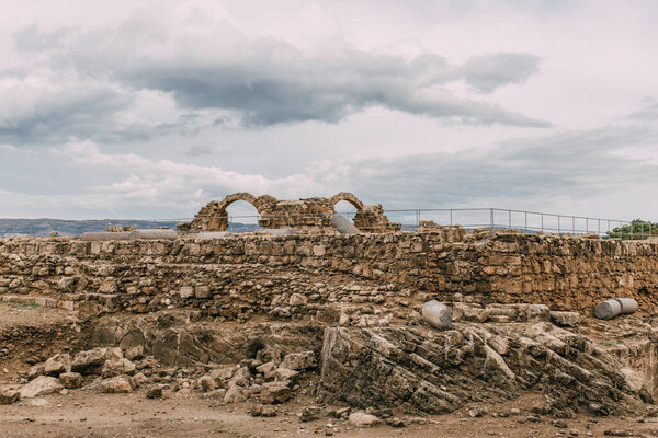ruins of old archaeological park against sky with clouds 