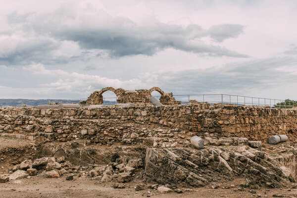 ruins of old archaeological park against sky with clouds 