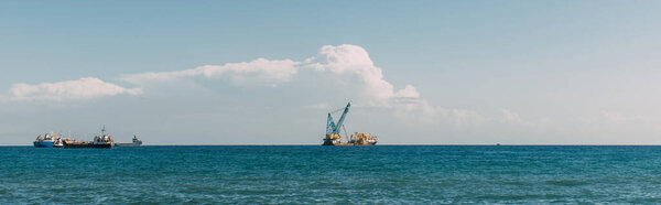 panoramic shot of ships in blue mediterranean sea against blue sky 