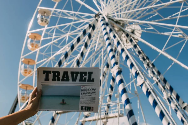 妇女在摩天轮附近拿着旅游报纸的剪影 — 图库照片