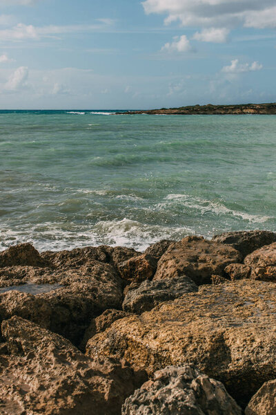 wet rocks near mediterranean sea against blue sky 
