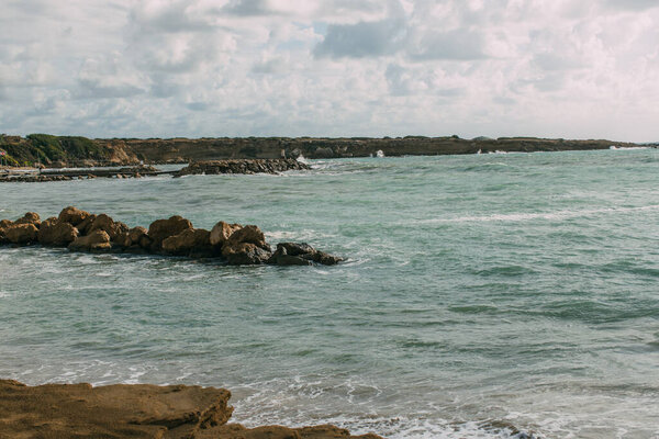 wet stones in blue mediterranean sea against sky 