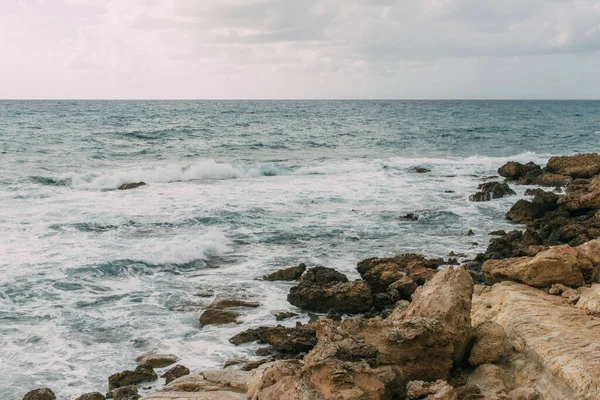 coastline of mediterranean sea against sky with clouds in cyprus