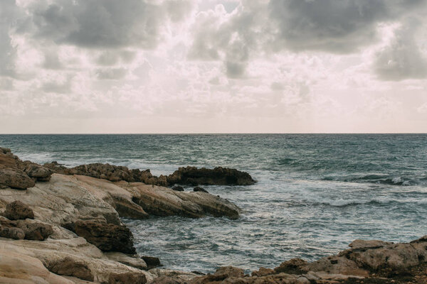 coastline near mediterranean sea against grey sky with clouds 