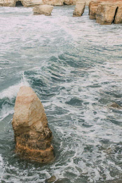 white foam near wet stones in water of mediterranean sea in cyprus  