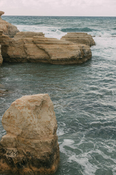 white foam near rocks in water of mediterranean sea 