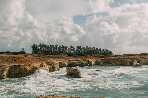 coastline of mediterranean sea against sky with white clouds 