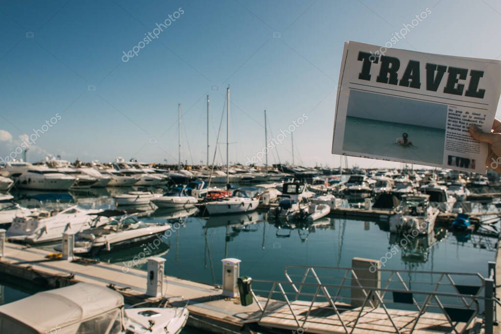 vista ritagliata di donna che tiene giornale di viaggio vicino alle navi attraccate nel mare Mediterraneo