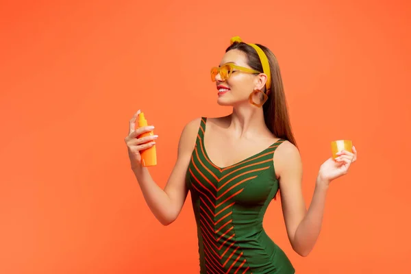 Vrouw Lachend Zonnebrandcrème Aanbrengen Geïsoleerd Oranje — Stockfoto