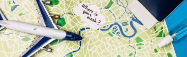 Top view of toy plane near speech bubble with what is your mask lettering near passport on map on blue surface, panoramic shot clipart