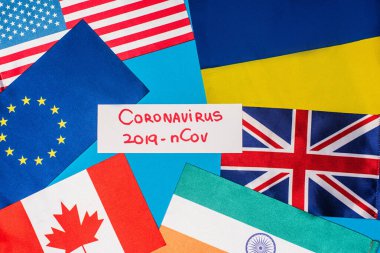 Mavi yüzey ülkelerinin bayraklarının yanında Coronavirus 2019-nCov harfleri olan en iyi kart görüntüsü