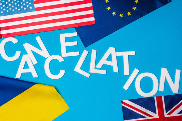 Вид сверху на флаги стран с отменяющимися льготами на синем фоне
