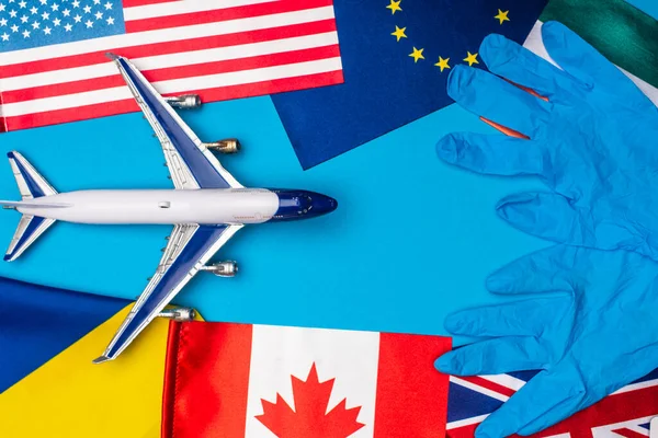 Top View Flags Countries Latex Gloves Toy Plane Blue Background — Stock Photo, Image