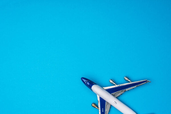 Top view of toy airplane on blue background with copy space