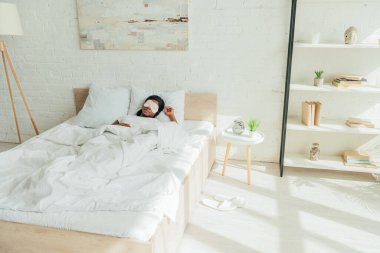 young african american woman sleeping in spacious bedroom clipart