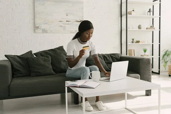 Довольно Африканская Американская Девушка Используя Ноутбук Держа Кредитную Карту Сидя — стоковое фото