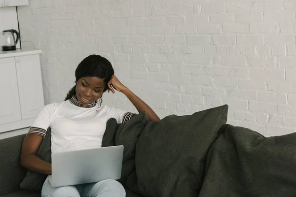 Sonriente Afroamericano Freelancer Sentado Sofá Utilizando Ordenador Portátil —  Fotos de Stock