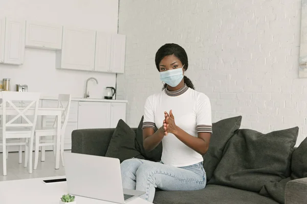 Jovem Freelancer Afro Americano Máscara Médica Desinfetando Mãos Enquanto Sentado — Fotografia de Stock