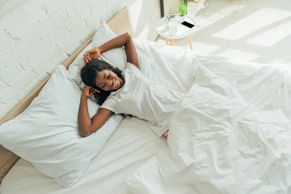 Draufsicht Auf Fröhliche Schöne Afrikanisch Amerikanische Mädchen Die Lächelnd Bett — Stockfoto
