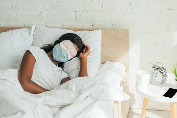 Afrikanska Amerikanska Kvinna Sömnmask Och Medicinsk Mask Sover Vitt Sängkläder — Stockfoto