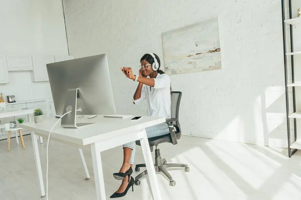 Alegre Afroamericano Freelancer Gesto Mientras Escucha Música Auriculares Inalámbricos Cerca —  Fotos de Stock