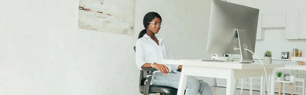 주방에서 일하는 아프리카 미국인 프리랜서가 컴퓨터 모니터를 파노라마 — 스톡 사진