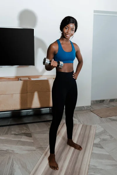 아프리카 미국인 여자가 엉덩이 훈련에 위에서 웃으며 거실에서 카메라를 — 스톡 사진