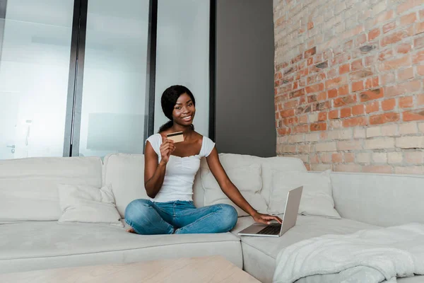 Afroamerikanerin Lächelt Schaut Die Kamera Zeigt Kreditkarte Und Benutzt Laptop — Stockfoto